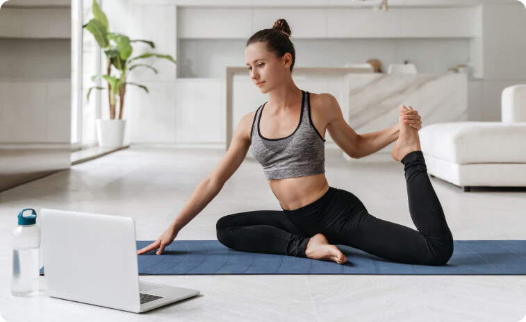Yoga practitioner following an online YogaFit class from home