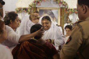 Amma the Hugging Saint sharing a ceremonial hug, reflecting somatic presence and heart awareness